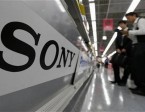 A Sony logo is seen as customers look at Sony's digital cameras at an electronic shop in Tokyo