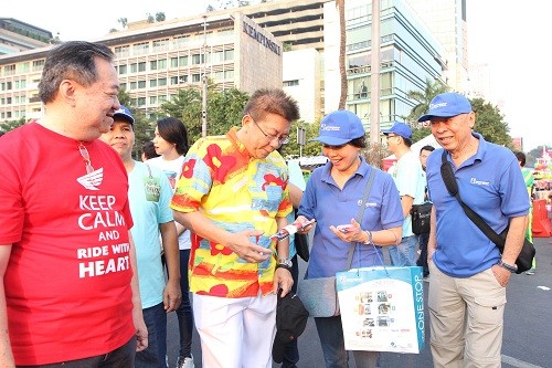 Tampak pada gambar: (ki-ka berbaju biru) Liana Setiawan – Sales Director PT Datascrip dan Joe Kamdani – Chairman & Founder pt. Datascrip memberikan cinderamata sebagai salah satu wujud apresiasi kepada peserta Parade Simpatik Hari Pelanggan Nasional 2015 di Jakarta pada Minggu, 6 September 2015.