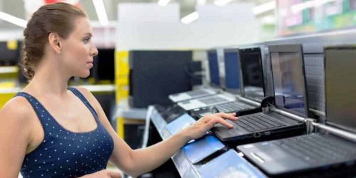 Raksasa Pasar PC Bekerja Sama di woman-looking-at-laptops-in-store
